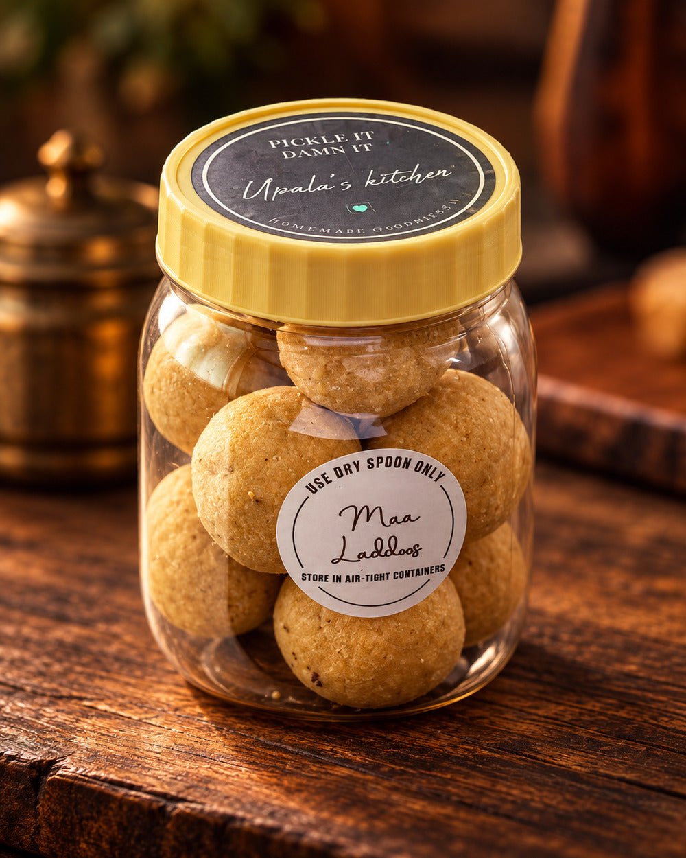 Upala’s Kitchen Maa Laddus in a clear jar with a yellow lid